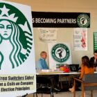 A sign says “Starbucks siren switches sides! Supports union & calls on company to sign fair election principle”.